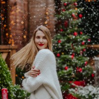 happy woman with blond hair standing under the snowfall in front yard - garden decoration stock pictures, royalty-free photos & images