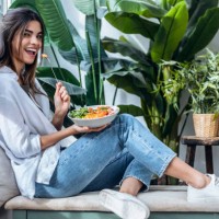 happy woman with bowl of salad at the window - food photos et images de collection