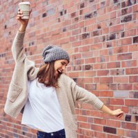 happy woman with coffee to go singing and dancing on the street - junk food stock pictures, royalty-free photos & images