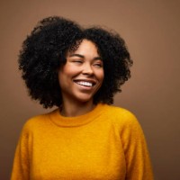 happy woman with curly hair against brown background - fashion stock pictures, royalty-free photos & images
