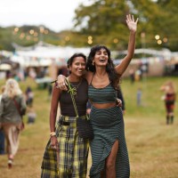 happy woman with female friend waving while walking - concert stock pictures, royalty-free photos & images