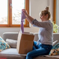 happy young attractive woman open cardboard box satisfied with purchase online shop order sit on sofa at home. - fashion stock pictures, royalty-free photos & images