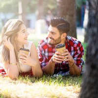 happy young couple drinking coffee in the park - junk food stock pictures, royalty-free photos & images