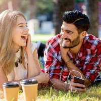 happy young couple listening music in the park - junk food stock pictures, royalty-free photos & images