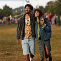 happy young couple looking away while walking at park - concert stock pictures, royalty-free photos & images