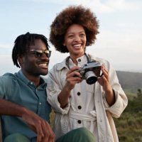 happy young couple with camera in national wildlife park - travel stock pictures, royalty-free photos & images