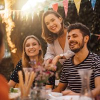 happy young male and female friends at table during dinner party in backyard - garden decoration stock pictures, royalty-free photos & images