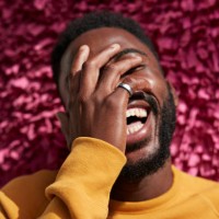 happy young man covering face against textured wall - fashion stock pictures, royalty-free photos & images