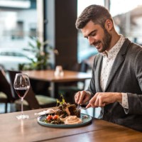 happy young man eating lunch at a restaurant. - food stockfoto's en -beelden