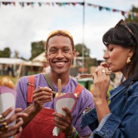 happy young man sharing dessert with female friend - junk food stock pictures, royalty-free photos & images