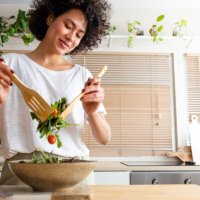 happy young multiracial woman mixing bowl of fresh salad. copy space.healthy lifestyle - food stock pictures, royalty-free photos & images
