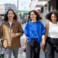 happy young people walking down the city street with a bicycle and smiling - fashion stock pictures, royalty-free photos & images