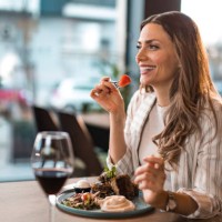 happy young woman eating lunch at a restaurant. - food stock pictures, royalty-free photos & images