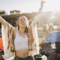 happy young woman with arms raised enjoying at music event during summer - fashion stock pictures, royalty-free photos & images
