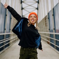 happy young woman with eyes closed sticking out tongue while dancing on footbridge - fashion stock pictures, royalty-free photos & images