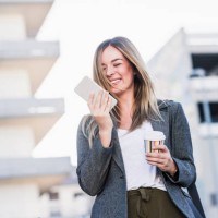 happy young woman with takeaway coffee and cell phone in the city - junk food stock pictures, royalty-free photos & images