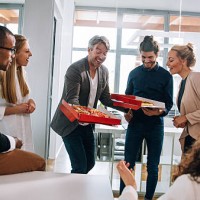head of department surprises business colleagues with pizza. - junk food stock pictures, royalty-free photos & images