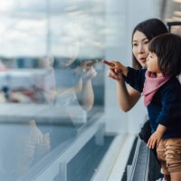 headshot of mother and toddler looking at view at the airport - travel stock pictures, royalty-free photos & images