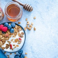 healthy food: homemade yogurt and granola shot from above on blue table. copy space - food stock pictures, royalty-free photos & images