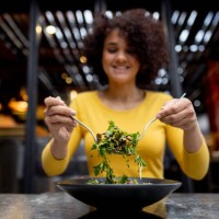 healthy woman eating a salad at a restaurant - food stock pictures, royalty-free photos & images