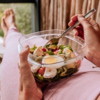 healthy young woman eating a fresh salad for lunch - junk food stock pictures, royalty-free photos & images