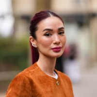 Heart Evangelista wears white gold diamond earrings, dark brown buttoned suede Akris blazer jacket, outside Akris, during the Paris Fashion week...
