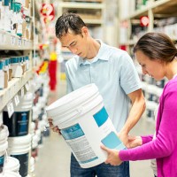 heterosexual couple choosing a paint type - home decoration stock pictures, royalty-free photos & images