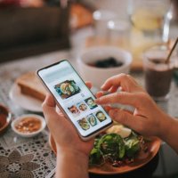 high angle view asian chinese woman's hand on mobile app for online food delivery during breakfast time - food stock pictures, royalty-free photos & images