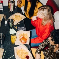 high angle view of male and female friends eating food at table in cafe - junk food stock pictures, royalty-free photos & images