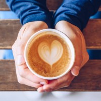 high angle view of someone hands holding a take away cup of hot latte coffee. - junk food stock pictures, royalty-free photos & images