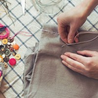 high angle view of woman stitching fabric on table at home - fashion stock pictures, royalty-free photos & images