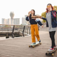 hipster women eating pizza and riding long boards - fashion stock pictures, royalty-free photos & images