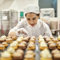 hispanic american female baker decorating vegan cupcakes - food stock pictures, royalty-free photos & images