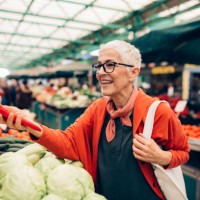 hogere vrouw die bij de markt van de landbouwer winkelt - food stockfoto's en -beelden
