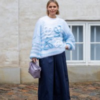 Hollie Mercedes Peters wears blue Loewe knit, wide leg shorts, lavender pink Loewe bag outside Marimekko during the Copenhagen Fashion Week...