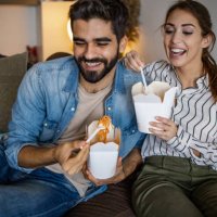 home delivery. couple relaxing at home and eating pasta - junk food stock pictures, royalty-free photos & images