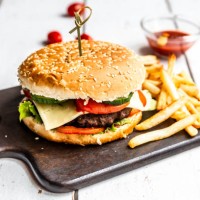 homemade hamburger with cheese, french fries, ketchup and tomato - junk food stockfoto's en -beelden
