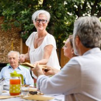 homme tendant une pile de serviettes à son ami qui installe la table - garden decoration photos et images de collection