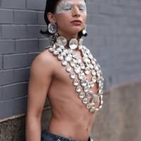 Honey Gonzales is seen wearing bejeweled Swarovski eye makeup, large round Swarovski crystals earrings, several layered necklaces with round...