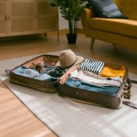 horizontal view of an open suitcase full of clothes ready to travel. - travel stock pictures, royalty-free photos & images