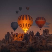 hot air balloons flying over rock formations at sunrise in cappadocia, goreme, turkey - travel stock pictures, royalty-free photos & images