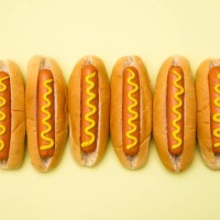 hot dogs against a plain background - junk food stockfoto's en -beelden