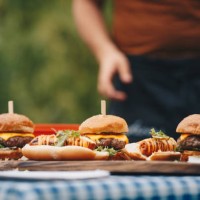 hot dogs and hamburgers placed on chopping board. - junk food stock pictures, royalty-free photos & images