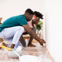 husband helping wife while painting apartment together - home decoration stock pictures, royalty-free photos & images