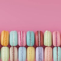illustration 3d of a group of different colored macaroons lined up on a pink background. - junk food stock-fotos und bilder