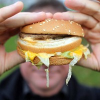 In this photo-illustration a man holds a burger from a fast food outlet on January 7, 2013 in Bristol, England. A government-backed TV advert - made...