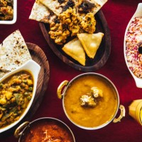 indian feast with butter chicken, chicken tandoori, lamb curry, vegetable curry, samosas, pakoras, bhajis, naan bread and basmati rice on a table. north indian food - food stock pictures, royalty-free photos & images