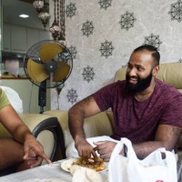 indian man laughing with brother - junk food stock pictures, royalty-free photos & images