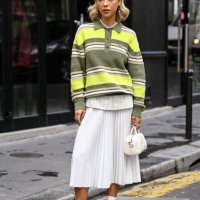 Ines Isaias is seen wearing a green striped Lacoste sweater, white shirt, white panel skirt, white socks, black shoes and Lacoste white bag outside...