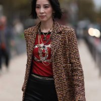 Irene Kim is seen outside Chanel show wearing gold Chanel necklaces, yellowish tweed Chanel coat, black leather shorts, golden Chanel belt, black...